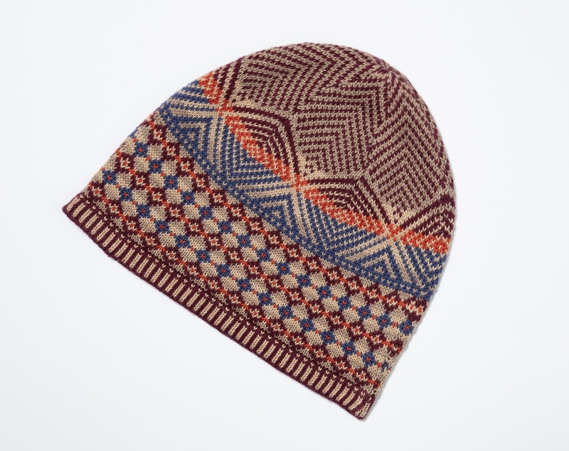 Baumwoll-Mix-Mütze mit geometrischem Muster in Braun, Beige, Blau und Orange, flach liegend auf weißem Hintergrund, feine Strickstruktur, gerippter Randabschluss.