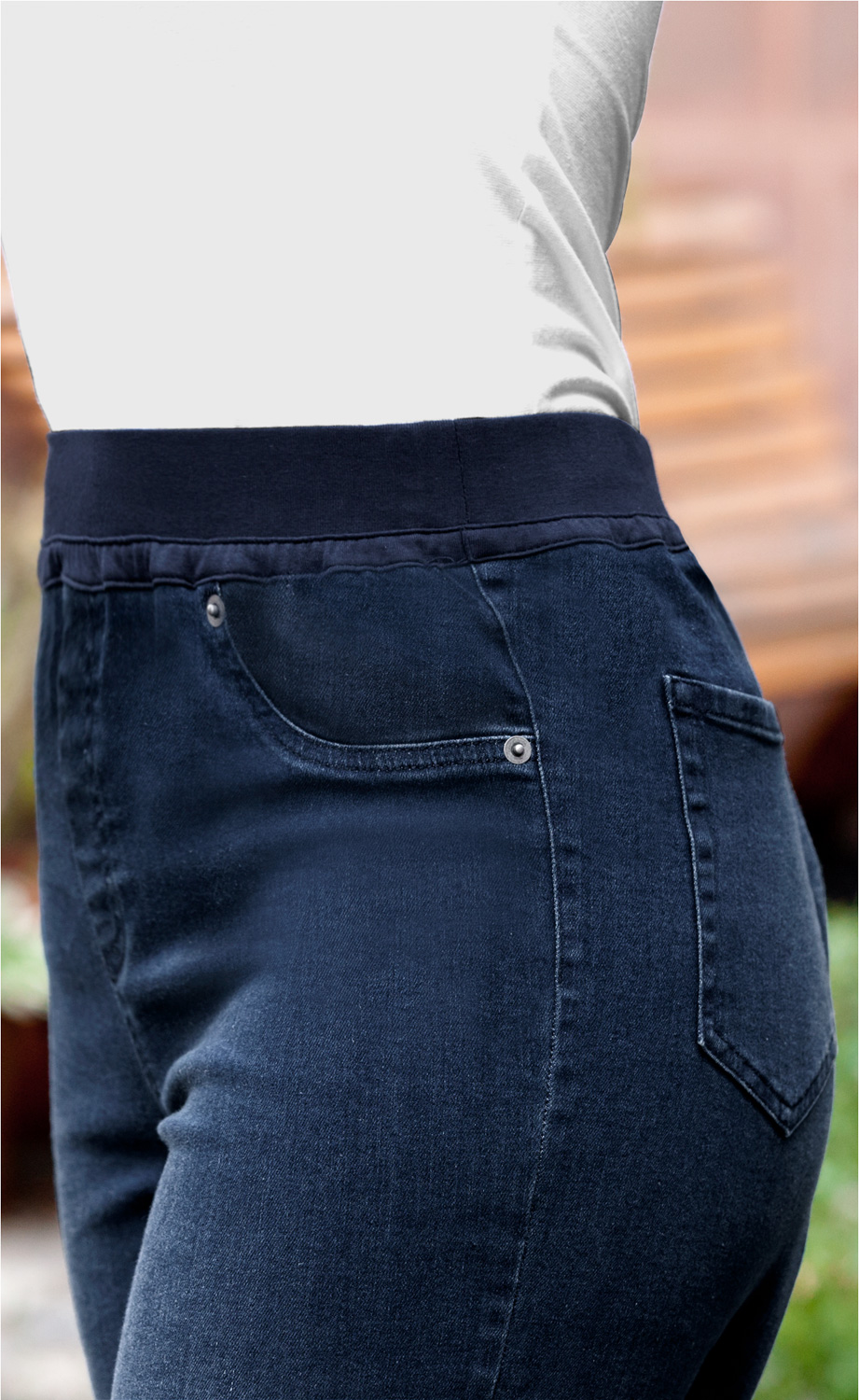 dunkelblaue Baumwoll-Hose mit elastischem Bund und Gesäßtasche, getragen mit weißem Oberteil, Nahaufnahme Hüftbereich