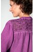 Bluse in violett mit Spitzeneinsatz am Rücken, leichte Falten unterhalb des Spitzeneinsatzes, lange Ärmel, getragen von seitlich stehendem Modell