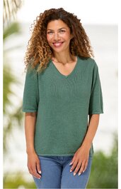 Olivgrünes kurzärmeliges Damenoberteil ohne Muster, V-Ausschnitt, gerade geschnitten, getragen von stehender Person mit locker fallendem lockigem Haar, legere Passform