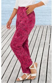 Hose in dunkelpink mit schwarzem Blumenmuster, gerade geschnitten, mit Taschen, getragen von seitlich stehender Person, hohe Taille, elastischer Bund