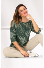Damenpullover dunkelgrün mit hellgrünem Blättermuster, rundhalsausschnitt, dreiviertellange Ärmel, getragen von sitzender Frau mit beige Hose und weißen Sneakers