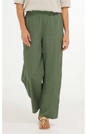 Olivegrüne, weit geschnittene Hose mit elastischem Bund, glatter Stoff, getragen von stehender Person, lockere Passform, keine sichtbaren Taschen