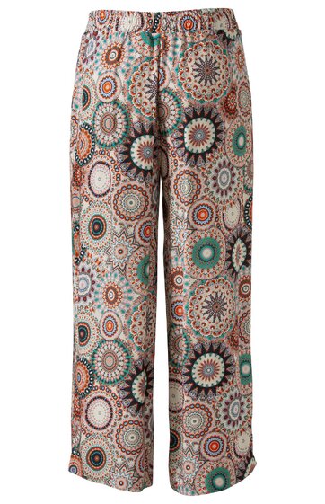 Locker geschnittene Hose mit elastischem Bund, bunte kreisförmige Muster in Rot, Grün, Beige auf hellbeigem Grund, gerade geschnittene Hosenbeine