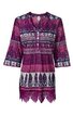 Tunika in dunkelviolett mit weißen und dunkelblauen floralen und geometrischen Mustern, V-Ausschnitt mit Knopfleiste, 3/4-Ärmel mit leichter Glockenform, seitliche Schlitze, unterer Saum mit Spitzenbesatz