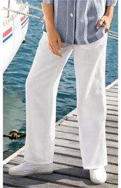 Weiße, gerade geschnittene Hose aus glattem Stoff, Bund mit Knopf und Reißverschluss, getragen von stehender Person, weiße Sneaker, Holzsteg und Wasser im Hintergrund