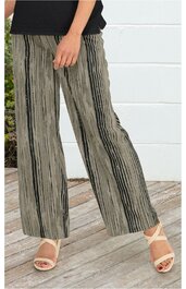 Weite Hose in Beige mit schwarzen vertikalen Streifen, gerader Schnitt, elastischer Bund, getragen von stehender Person mit schwarzem Oberteil, kombiniert mit beigen Sandaletten