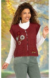 Bordeauxrotes Strickweste mit Blumenstickerei, V-Ausschnitt, Knopfleiste, getragen von lächelnder Frau mit lockigem Haar, lange weiße Unterziehshirt, grüne Hose