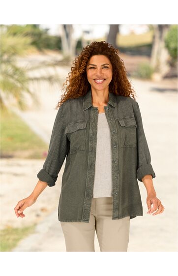 Olivegrünes Hemd mit feinem Nadelstreifenmuster, Kragen, durchgehende Knopfleiste, zwei Brusttaschen mit Klappen, lange Ärmel mit hochgekrempelten Ärmelabschlüssen, locker sitzend, getragen von stehender Frau