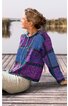 Pullover mit Kapuze in Violett und Blau, geometrisches Muster in Schwarz, langärmlig, vorne mit Kordelzug, locker geschnitten, getragen von sitzender Person seitlich gewandt auf Holzsteg am Wasser