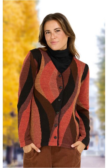 Damenstrickjacke in Rostrot, Dunkelbraun und Schwarz mit wellenförmigem Muster, V-Ausschnitt, Knopfleiste, langärmlig, getragen von stehender Frau mit schwarzen Rollkragenpullover und brauner Hose