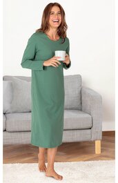 Grünes, langärmliges Kleid, knöchellang, gerade geschnitten, rundhalsausschnitt, getragen von stehender Frau, die eine weiße Tasse hält