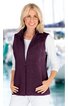 Dunkelviolette Damenweste ohne Ärmel, durchgehender Reißverschluss, Stehkragen, schmale Passform, getragen von lächelnder stehender Frau mit weißen, langärmligen Shirt und heller Hose