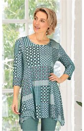 Tunika zur Damenbekleidung in Petrol und Blau, Patchwork-Muster aus geometrischen Formen, Rundhalsausschnitt, 3/4-Ärmel, locker fallend, von stehender Frau getragen