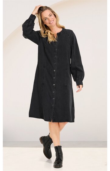 Schwarzes knielanges Hemdblusenkleid, durchgehende Knopfleiste vorne, Rundhalsausschnitt, lange Ballonärmel mit Bündchen, gerade geschnitten, getragen von stehender Frau, kombiniert mit schwarzen Schnürstiefeln