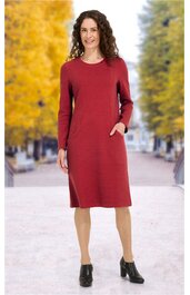 Rotes, knielanges Kleid mit rundem Ausschnitt, langen Ärmeln, aufgesetzten Taschen an den Seiten, gerade geschnitten, getragen von stehender Frau mit offenen Haaren, schwarze Stiefeletten