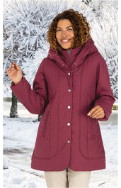 Damenjacke in dunklem Rot, glatt, Kapuze mit Tunnelzug, durchgehender Reißverschluss und Druckknöpfe, taillierter Schnitt, seitliche Eingrifftaschen, getragen von lächelnder Frau vor winterlicher Schneelandschaft