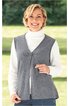 Graue ärmellose Strickweste mit V-Ausschnitt und durchgehendem Reißverschluss vorne, getragen von lächelnder Frau im Stehen, darunter weißer Rollkragenpullover, gerade geschnitten