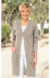 Hellgraue, knielange Strickjacke mit V-Ausschnitt, langer Arm, zwei aufgesetzte Taschen, ein Knopfverschluss, getragen von lächelnder stehender Frau mit kurzen blonden Haaren