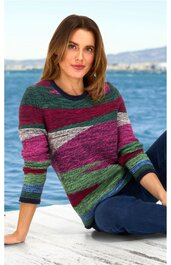 Pullover mit Rundhalsausschnitt, mehrfarbig gestreift in Tönen von Grün, Bordeaux, Pink, Grau und Blau, lange Ärmel, getragen von sitzender Frau mit lockeren blonden Haaren, kombiniert mit blauer Hose