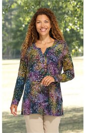 Langärmliges Tunika-Oberteil in lila, grün und blau mit floralem Muster, V-Ausschnitt mit Knopfleiste, gerade geschnitten, getragen von stehender Frau
