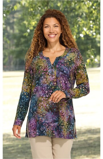 Langärmliges Tunika-Oberteil in lila, grün und blau mit floralem Muster, V-Ausschnitt mit Knopfleiste, gerade geschnitten, getragen von stehender Frau