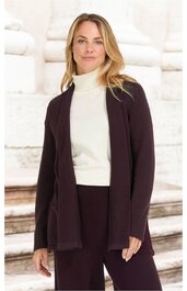 Dunkellila offene Strickjacke, lange Ärmel, zwei aufgesetzte Taschen, getragen von stehender Frau mit weißen Rollkragenpullover und dunkler Hose