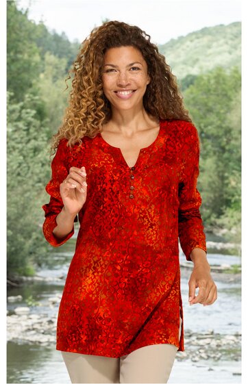 Rotes Langarmshirt mit abstraktem Muster, Rundhalsausschnitt mit kleinem Schlitz, lockere Passform, getragen von stehender Frau vor Naturhintergrund