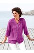 Bluse in magentaviolett, unifarben, mit Knopfleiste vorne, Stehkragen, 3/4-Ärmeln, Spitzenbesatz an Schultern und Saum, getragen von sitzender Frau am Holzsteg mit Blick aufs Wasser