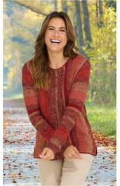 Pullover in Rot- und Orangetönen mit Streifenmuster, Rundhalsausschnitt, lange Ärmel, gerade Form, getragen von lachender Frau im Freien auf Waldweg