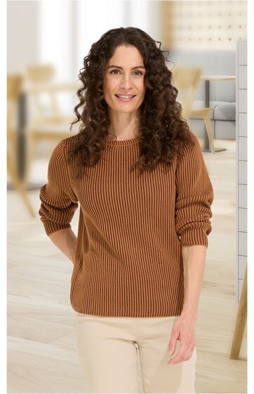 Pullover in warmem Braunton mit feinem Rippenmuster, Rundhalsausschnitt, lange Ärmel, gerade geschnitten, getragen von stehender Frau mit lockigen braunen Haaren