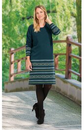 Dunkelgrünes Strickkleid mit Norwegermuster in Hellgrün und Hellgrau an Ärmeln und Saum, Rundhalsausschnitt, lange Ärmel, knielang, getragen von stehender Frau, gerade geschnitten