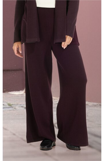 Dunkelbraune weite Hose ohne Muster, mit geradem Schnitt, getragen von stehender Person, hoher Bund, kombiniert mit dunkelbraunem Oberteil