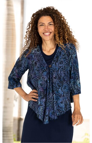 Dunkelblauer Blazer mit Paisleymuster in Blau- und Violetttönen, 3/4-Ärmeln, asymmetrischem Saum, Reverskragen, getragen von lächelnder Frau in stehender Pose