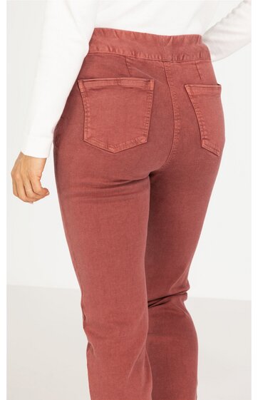 Damenhose in rostrot, einfarbig, mit zwei aufgesetzten Gesäßtaschen, elastischer Bund, gerade geschnitten, getragen von einer Person im Stehen, von hinten sichtbar