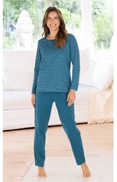 Damen-Pyjama in Blau, langärmlig, Oberteil mit horizontalen, dunkleren Streifen, Rundhalsausschnitt, gerade geschnitten, lange Hose ohne Muster, elastischer Bund, getragen von stehender Frau, barfuß