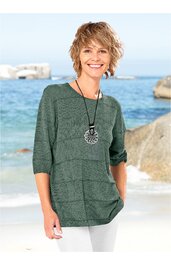 Grüner Pullover mit horizontalem Streifenmuster, rundem Ausschnitt, halblangen Ärmeln, locker sitzend, getragen von stehender Person vor Strandkulisse