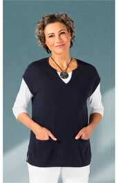 Damenweste dunkelblau, ärmellos, V-Ausschnitt, zwei aufgesetzte Taschen, getragen von stehender Frau mit weißen Dreiviertelarmshirt und weißer Hose