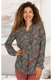 Langärmlige Bluse in dunklem Olivgrün mit floralen rosa Mustern, durchgehende Knopfleiste, Stehkragen, gerade geschnitten, getragen von stehender Frau mit einer Hand in der Hüfte