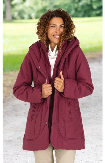 Damenjacke weinrot, Kapuze, durchgehender Reißverschluss, hohe Taille, zwei große aufgesetzte Taschen, lange Ärmel, getragen von lächelnder stehender Frau