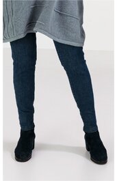 Dunkelblaue Jeanshose eng anliegend, hüfthoch, ohne sichtbare Taschen, getragen von Person stehend, schwarze Stiefeletten mit mittelhohem Absatz, grauer Pullover bis zur Hüfte teilweise sichtbar