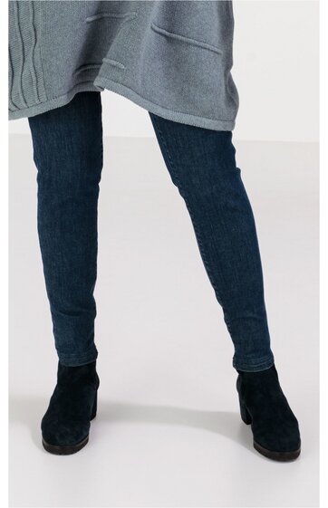 Dunkelblaue Jeanshose eng anliegend, hüfthoch, ohne sichtbare Taschen, getragen von Person stehend, schwarze Stiefeletten mit mittelhohem Absatz, grauer Pullover bis zur Hüfte teilweise sichtbar