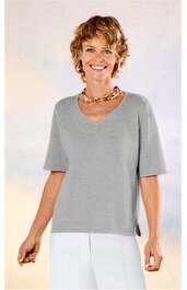 Hellgraues Kurzarmshirt mit V-Ausschnitt, gerader Saum mit kleinen Seitenschlitzen, getragen von stehender Frau, locker sitzend