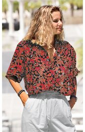 Damenbluse in dunkelrot mit schwarzem und hellbeige floralem Muster, kurzer Arm, Kragen, Knopfleiste, weit geschnitten, getragen von stehender Frau mit freiem Blick nach rechts