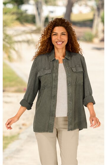 Olivegrünes Hemd mit feinem Nadelstreifenmuster, Kragen, durchgehende Knopfleiste, zwei Brusttaschen mit Klappen, lange Ärmel mit hochgekrempelten Ärmelabschlüssen, locker sitzend, getragen von stehender Frau