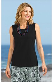 Ärmelloses schwarzes Top mit rundem Halsausschnitt, getragen von lächelnder stehender Frau, kombiniert mit weißen Shorts mit schwarzem Spiralmuster, mehrreihige bunte Ketten als Accessoire