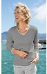 Langarmshirt in hellgrau mit weißem V-Ausschnitt und weißen Ärmelbündchen, gerade geschnitten, getragen von stehender lachender Frau vor Meer und blauem Himmel