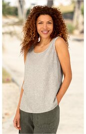 Ärmelloses, hellgraues Top mit Rundhalsausschnitt, gerade geschnitten, getragen von stehender Frau mit lockigen braunen Haaren, grüne Hose, rechte Hand in Hosentasche