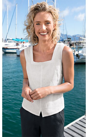 Weißes ärmelloses Oberteil mit quadratischem Ausschnitt, gerade geschnittener Saum, getragen von lächelnder Frau vor Hafen mit Booten, lockere Passform