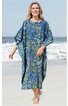 Blaues Kaftankleid mit floralen gelben und grünen Mustern, rundem Ausschnitt, weitem Schnitt, kurze Ärmel, getragen von lächelnder stehender Frau am Strand, knöchellang